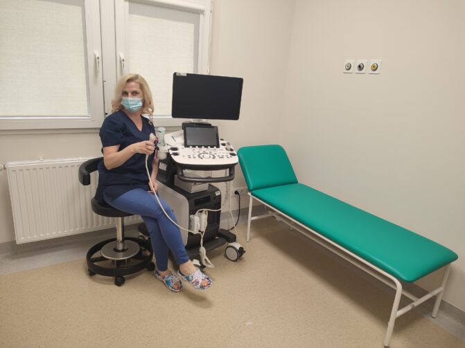 Zdjęcie przedstawia pielęgniarkę siedzącą przy aparacie USG i nowej kozetce